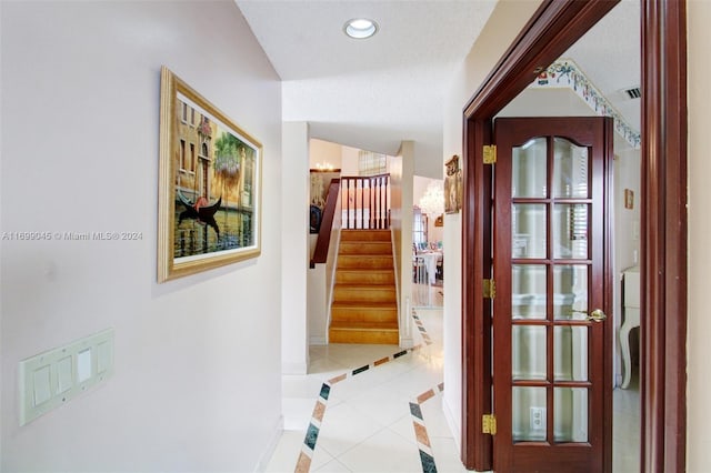 hall with light tile patterned floors and a textured ceiling