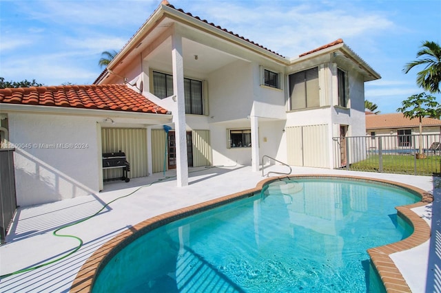 view of swimming pool featuring area for grilling and a patio