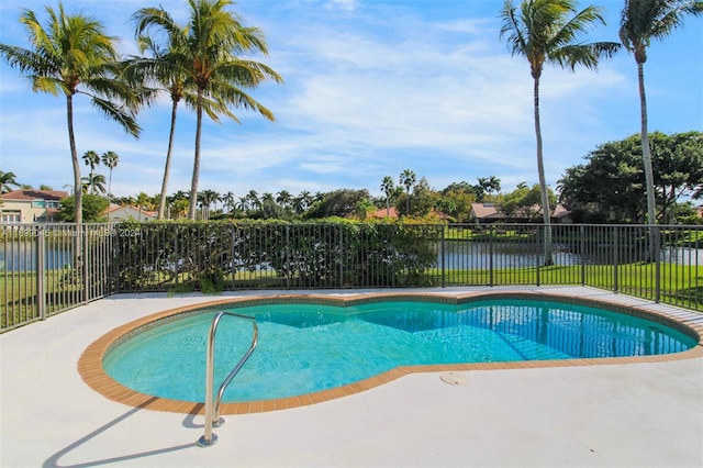 view of swimming pool featuring a water view and a patio