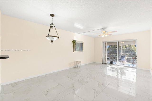 empty room featuring ceiling fan and a textured ceiling