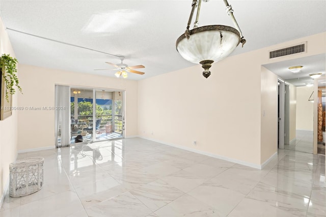 spare room featuring ceiling fan and a textured ceiling