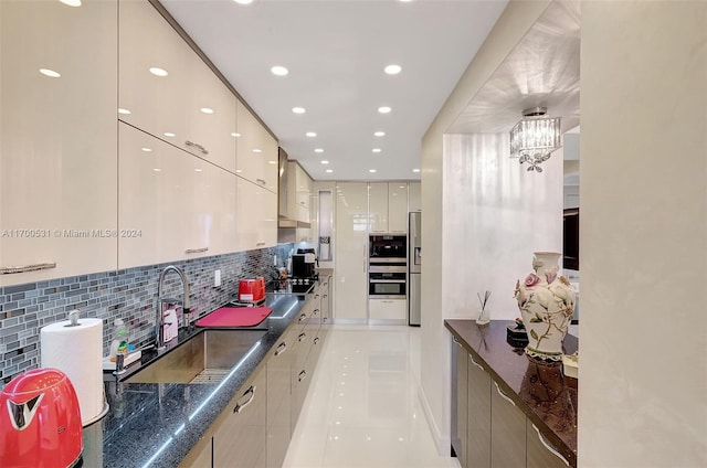 kitchen with sink, wall chimney exhaust hood, tasteful backsplash, light tile patterned flooring, and stainless steel appliances