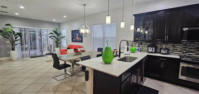 kitchen featuring appliances with stainless steel finishes, backsplash, light tile patterned floors, and sink