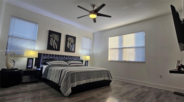 bedroom with dark hardwood / wood-style floors and ceiling fan