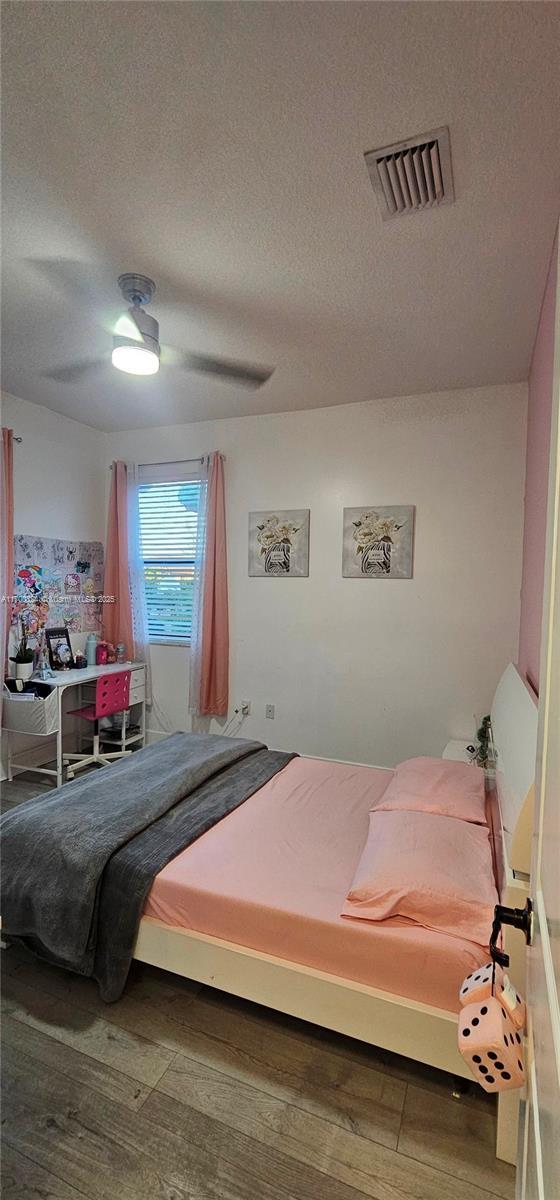 bedroom featuring wood-type flooring, a closet, and ceiling fan