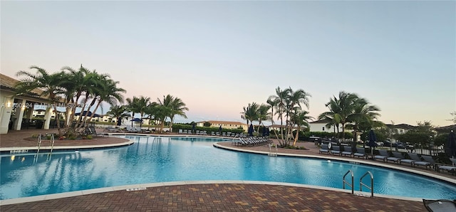 pool at dusk with a patio area