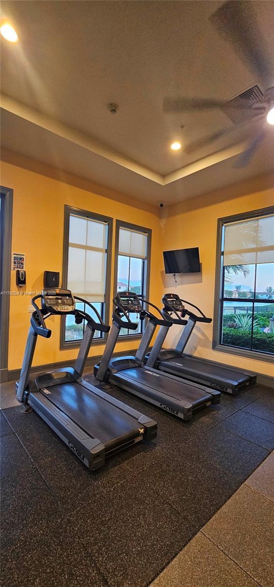 gym featuring ceiling fan and a textured ceiling