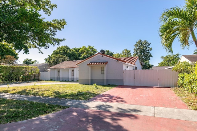 mediterranean / spanish home with a front lawn