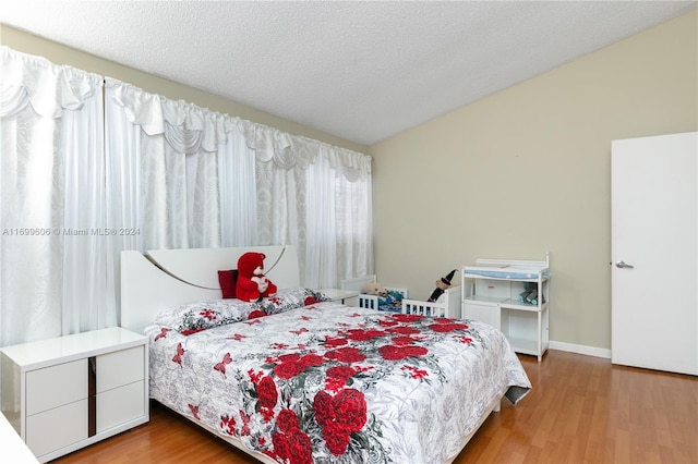 bedroom featuring wood-type flooring and a textured ceiling