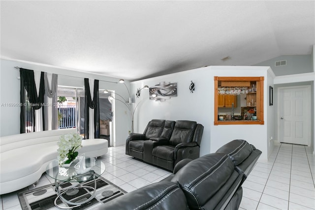 living room with lofted ceiling, a textured ceiling, and light tile patterned floors