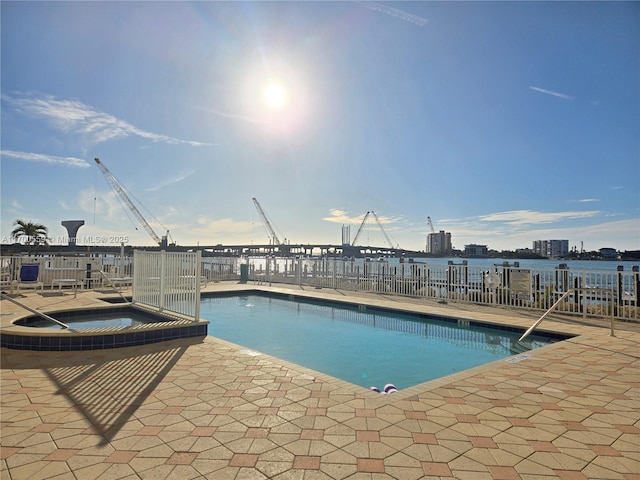 pool featuring a patio, a community hot tub, and fence