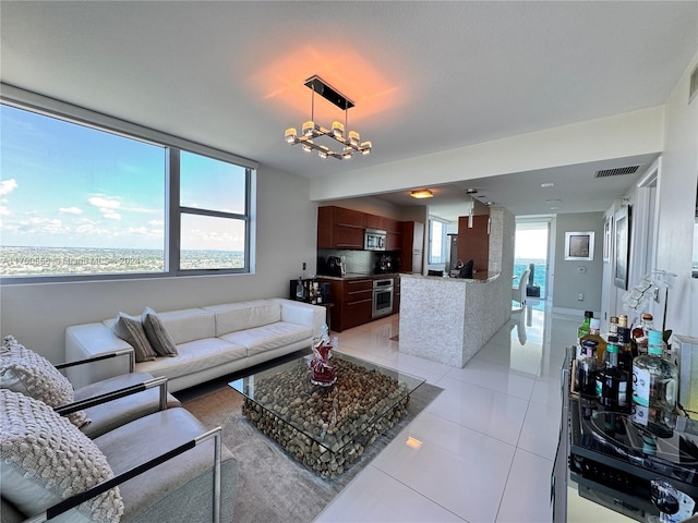 tiled living room with a notable chandelier