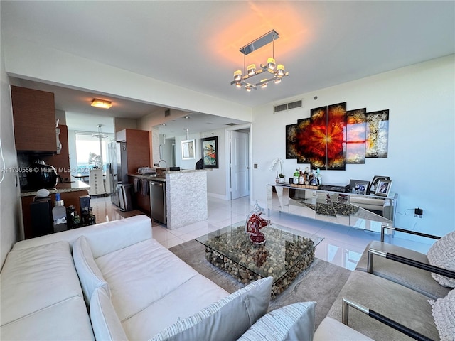 tiled living room featuring sink and a chandelier