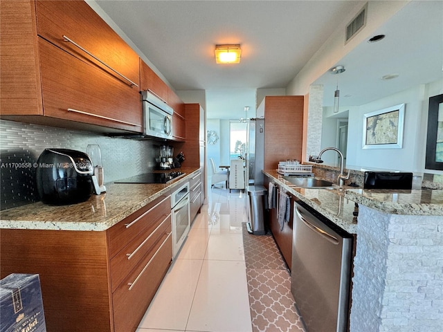 kitchen featuring backsplash, sink, light tile patterned floors, light stone counters, and stainless steel appliances