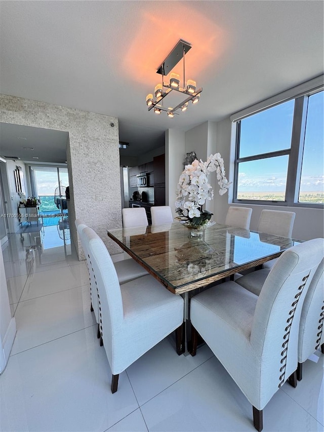 dining room with a notable chandelier, a healthy amount of sunlight, and light tile patterned flooring