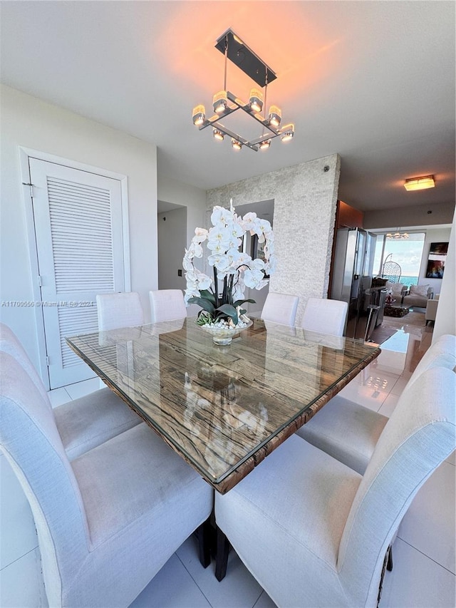 tiled dining room with a notable chandelier