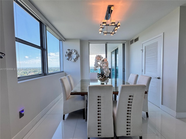 dining space featuring light tile patterned floors, a wealth of natural light, and a chandelier