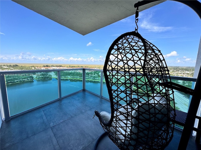 balcony with a water view and a view of the beach