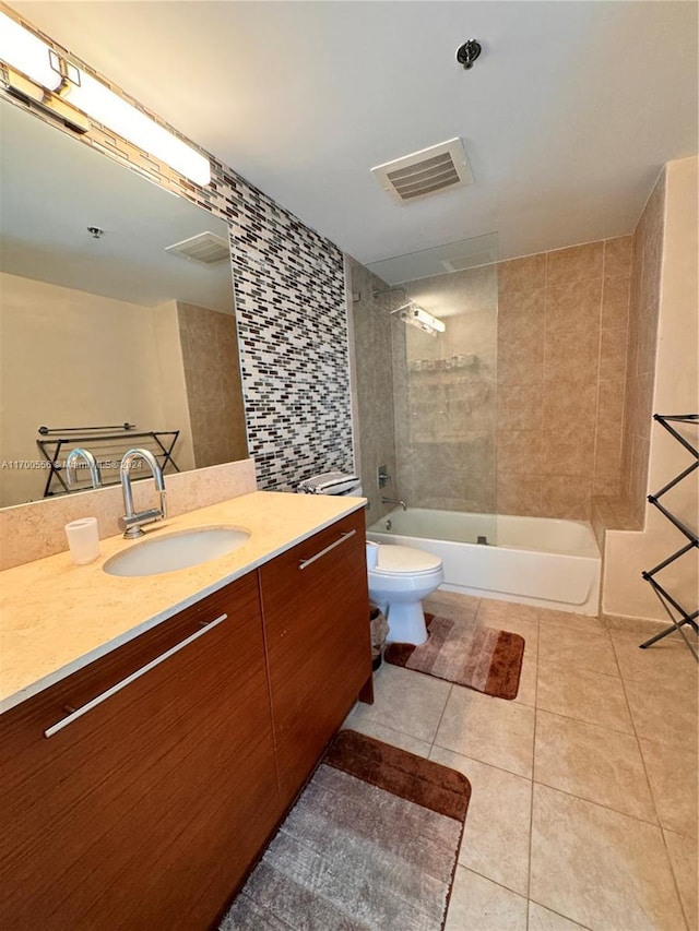 full bathroom with vanity, tiled shower / bath combo, toilet, and tile patterned flooring