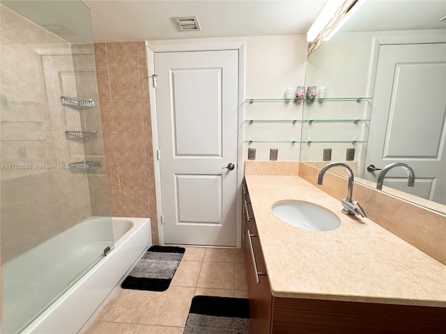 bathroom with tile patterned floors, vanity, and tiled shower / bath