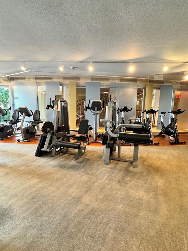 workout area with carpet flooring and a textured ceiling