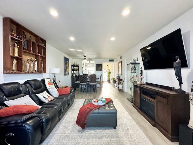 living room with ceiling fan and light hardwood / wood-style flooring