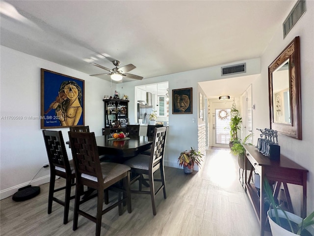 dining space with hardwood / wood-style floors and ceiling fan