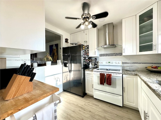 kitchen with white cabinets, black fridge with ice dispenser, electric range, and wall chimney range hood