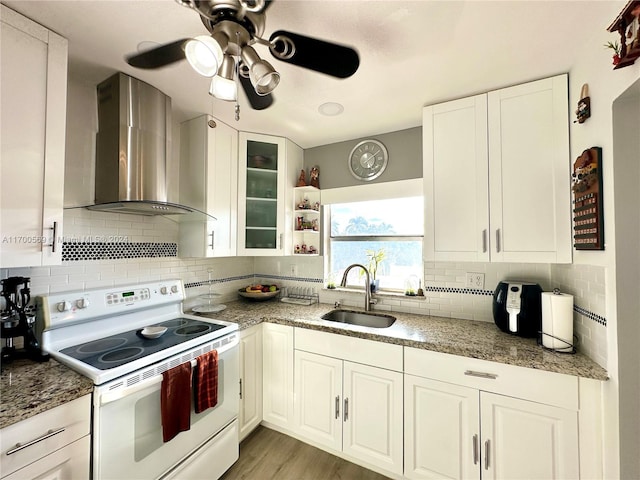 kitchen with backsplash, white cabinets, sink, wall chimney exhaust hood, and white range with electric stovetop