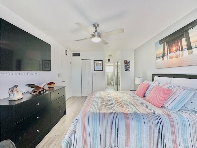 bedroom with ceiling fan, a closet, light wood-type flooring, and ensuite bath