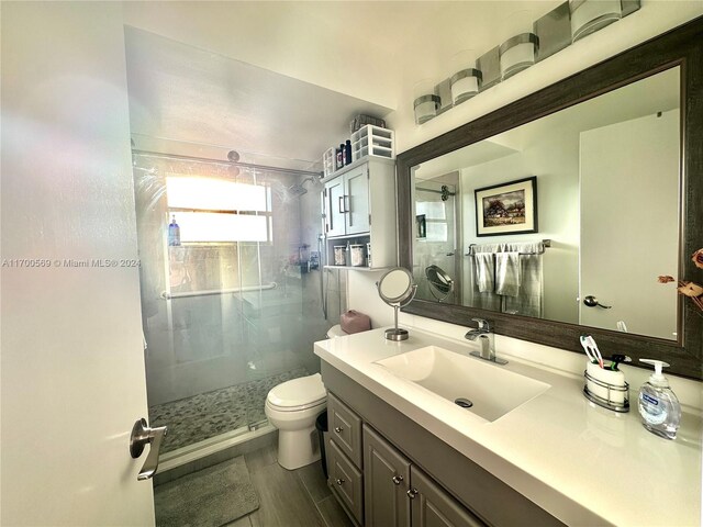 bathroom with tile patterned flooring, vanity, toilet, and a shower with door