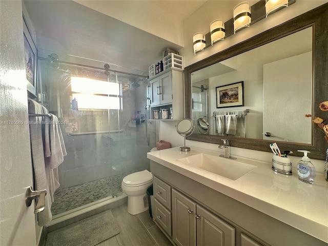 bathroom featuring vanity, toilet, and a shower with shower door