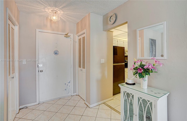 foyer featuring light tile patterned floors and a textured ceiling