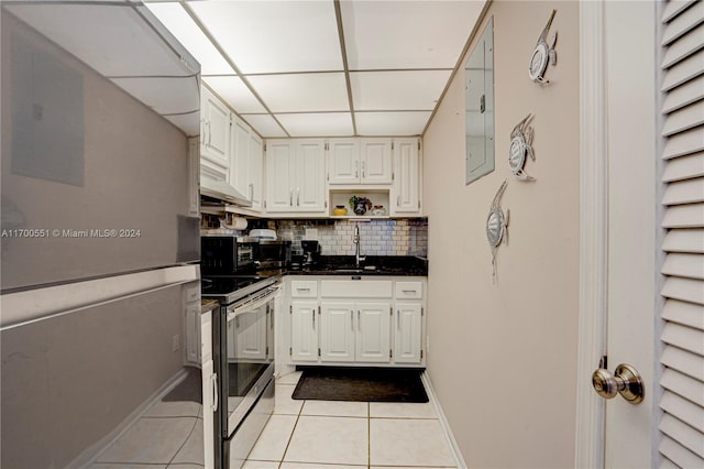 kitchen with backsplash, white fridge, stainless steel electric range oven, and light tile patterned flooring