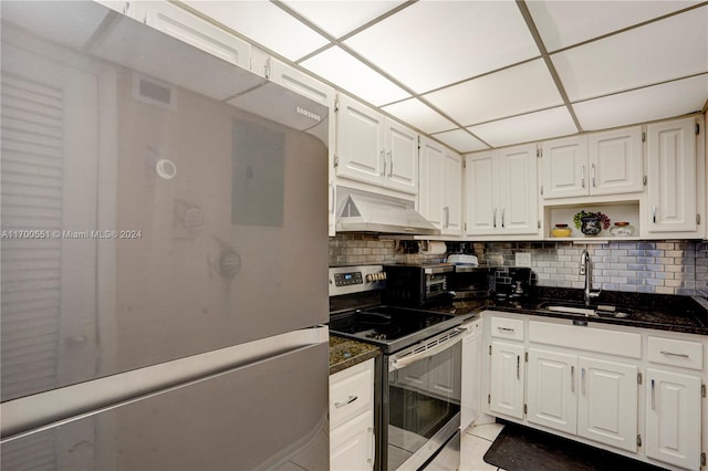 kitchen featuring stainless steel range with electric cooktop, ventilation hood, refrigerator, sink, and white cabinetry