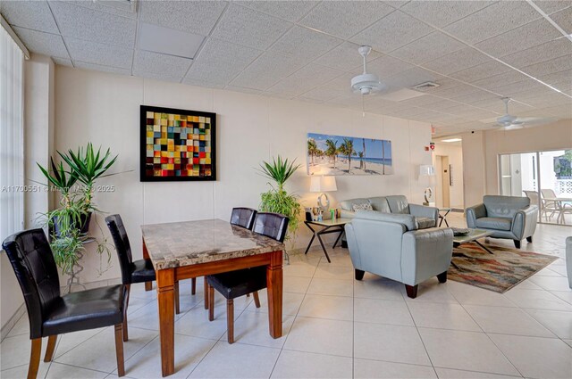 interior space with light tile patterned floors, a drop ceiling, and ceiling fan