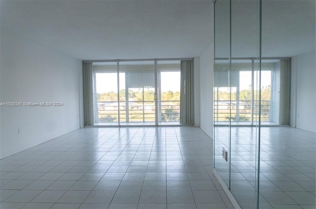 16850 S Glades Dr Unit 3C, North Miami Beach, FL 33162 - empty room with a wall of windows, plenty of natural light, and tile patterned flooring
