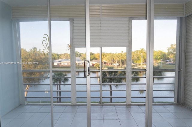 doorway featuring a water view and light tile patterned floors