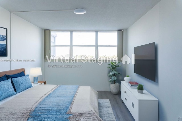 bedroom featuring a wall of windows and dark wood-type flooring