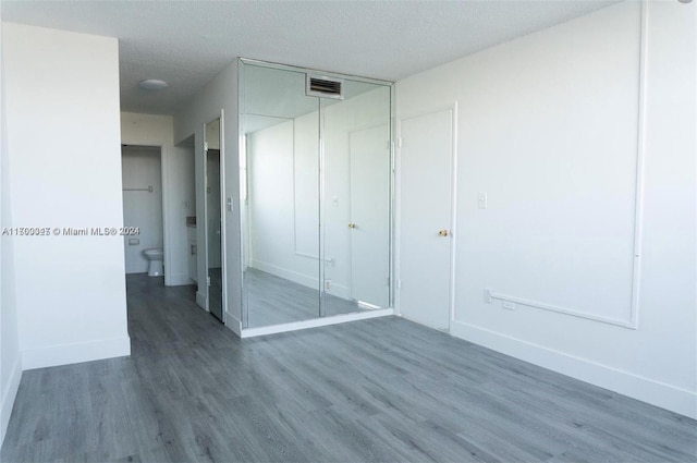 16850 S Glades Dr Unit 3C, North Miami Beach, FL 33162 - unfurnished bedroom featuring wood finished floors, a closet, and a textured ceiling