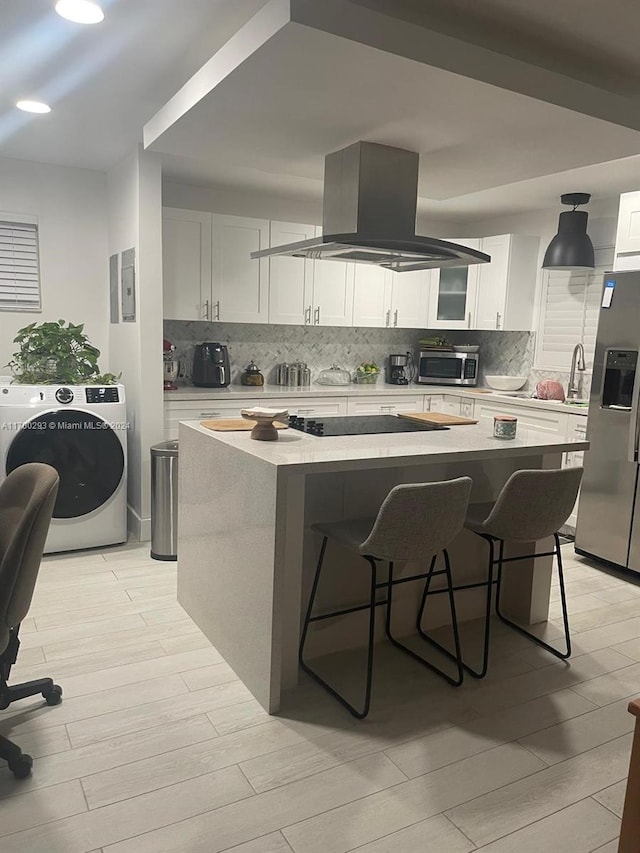 kitchen with island range hood, a kitchen island, white cabinetry, and stainless steel refrigerator with ice dispenser