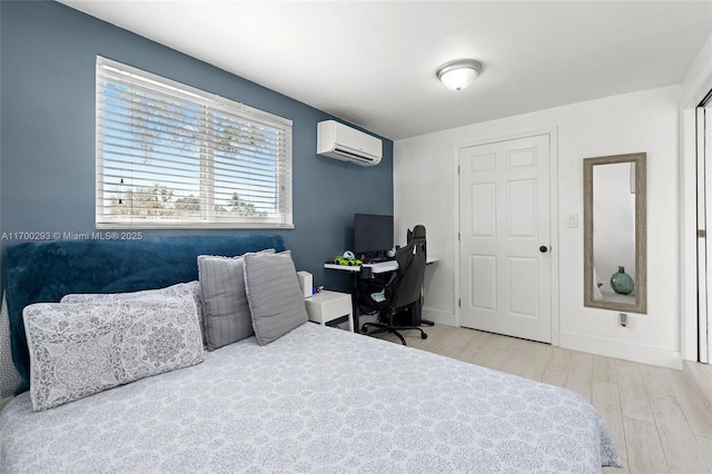 bedroom featuring light hardwood / wood-style flooring and a wall mounted AC