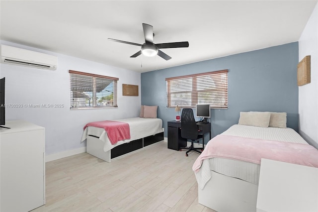 bedroom with a wall unit AC, multiple windows, ceiling fan, and light hardwood / wood-style flooring