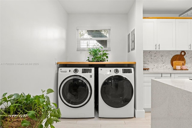 washroom with independent washer and dryer and cabinets