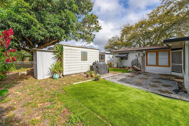 view of yard featuring a storage unit and a patio