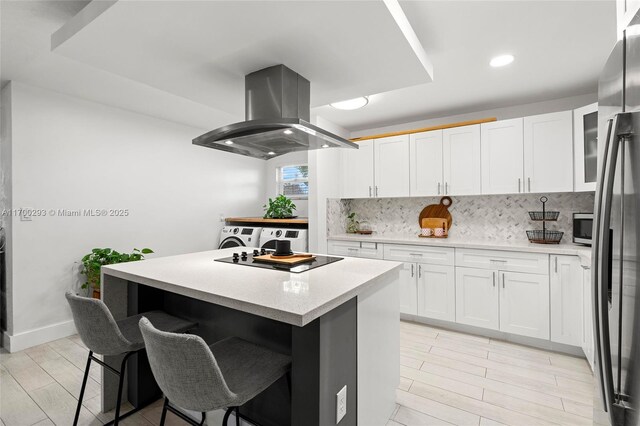 kitchen with a kitchen island, decorative backsplash, white cabinets, and island exhaust hood