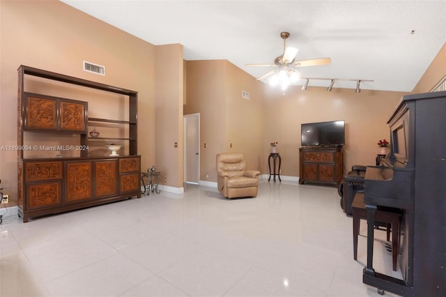 living area with a high ceiling, rail lighting, tile patterned floors, and ceiling fan