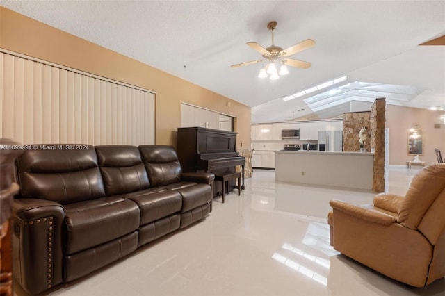 living room with a textured ceiling, ceiling fan, and vaulted ceiling