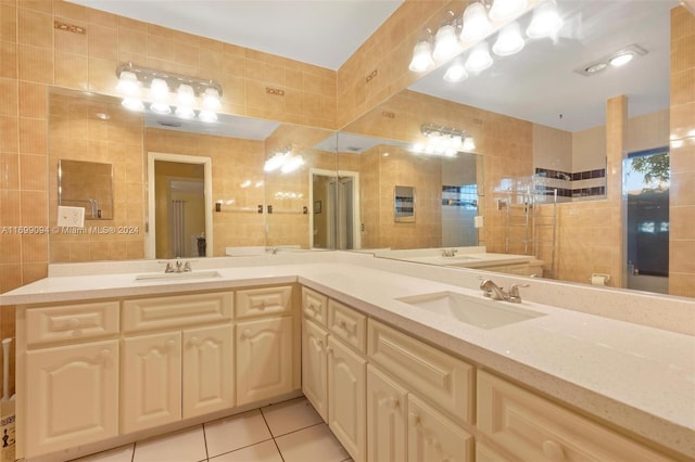 bathroom featuring tile patterned flooring, vanity, and tile walls