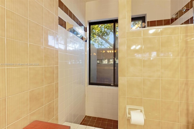 bathroom with tile walls and walk in shower